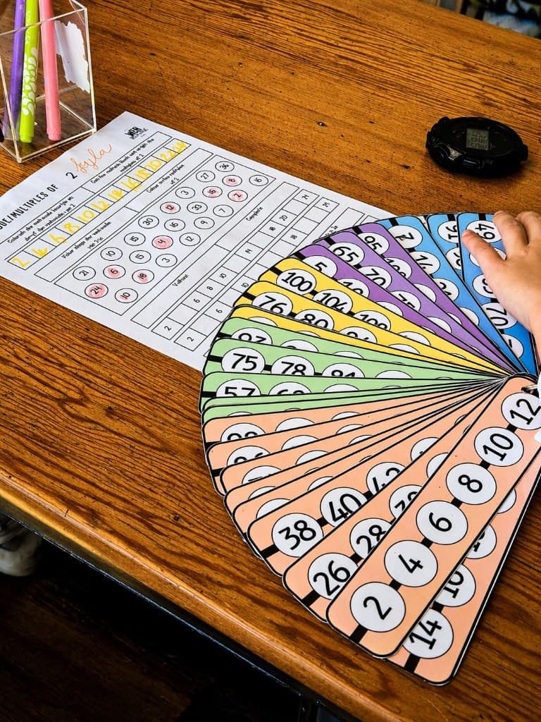 Rainbow fan of multiples flashcards on a classroom desk
