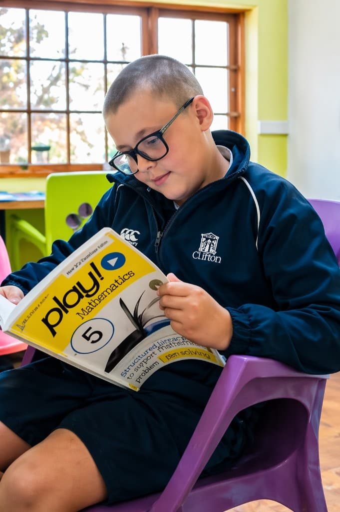 Learner reading a Play Mathematics workbook