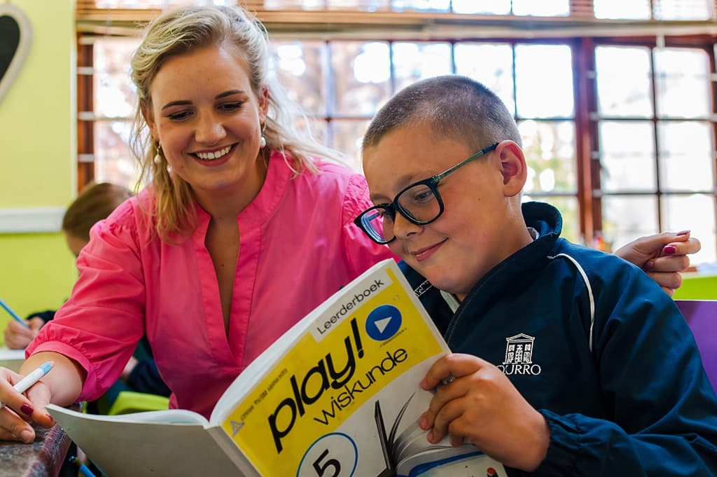 Tutor helping a learner with a Play Wiskunde workbook